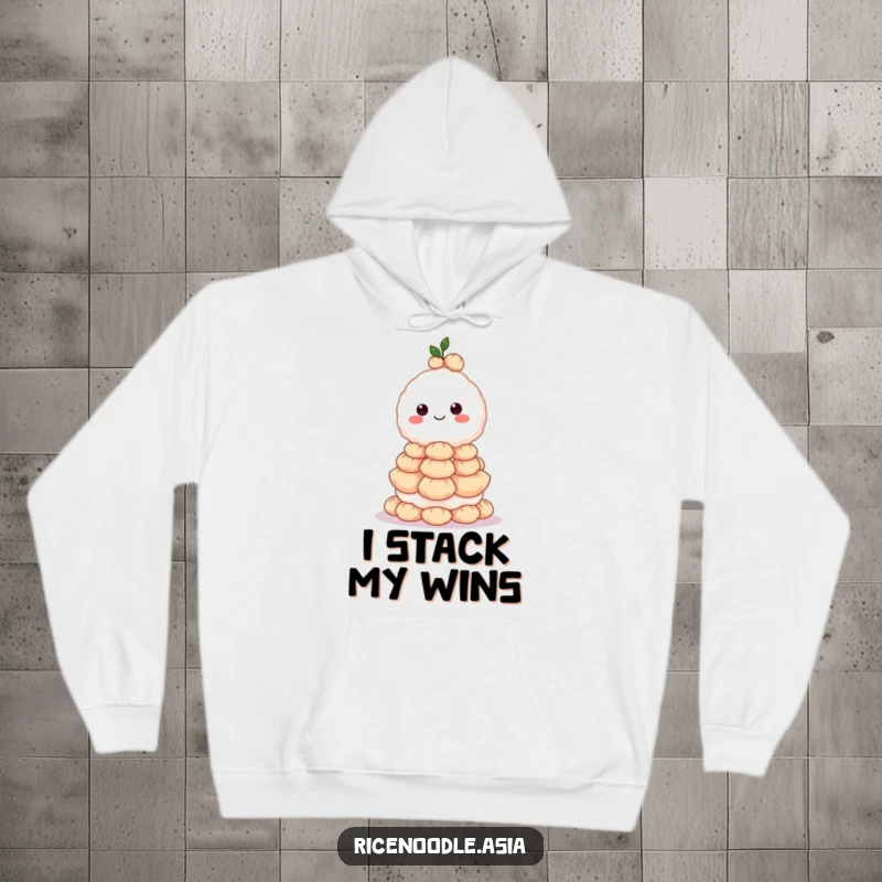 Funny hoodie with a grinning rice ball character depicted balancing a huge stack of dumplings, looking impressively focused.